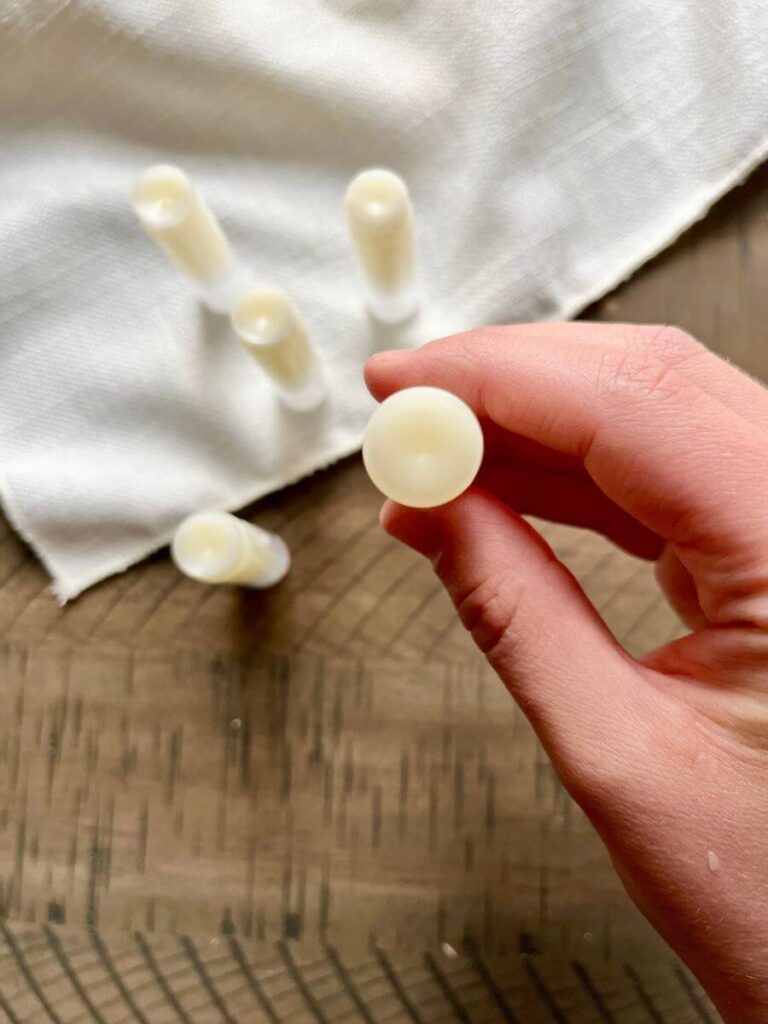 Girl holds DIY lip balm containers in her hand