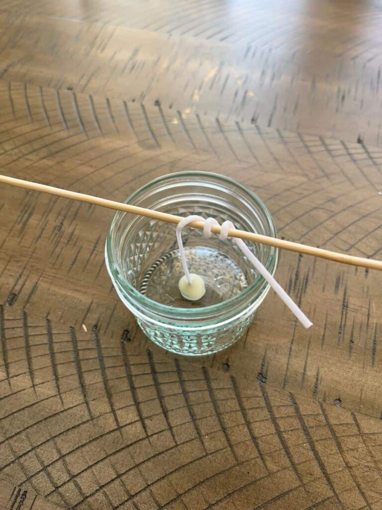 A stick is supporting the candle's wick